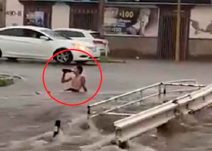 ¡Si miedo al éxito! Con cerveza en mano hombre enfrenta inundación en México