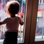 Menor de edad frente a una ventana