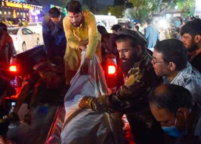 Voluntarios y personal médico trasladan a un herido para que reciba tratamiento tras dos potentes explosiones