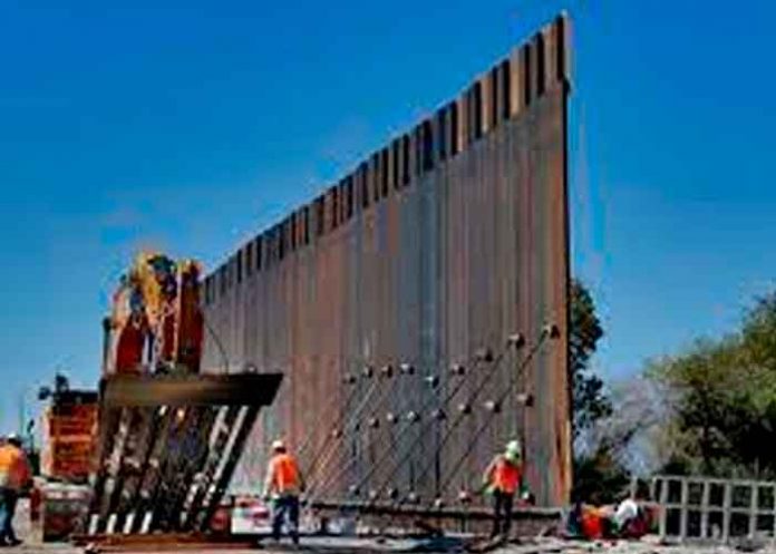 Varias personas trabajando en el muro fronterizo de EE.UU.