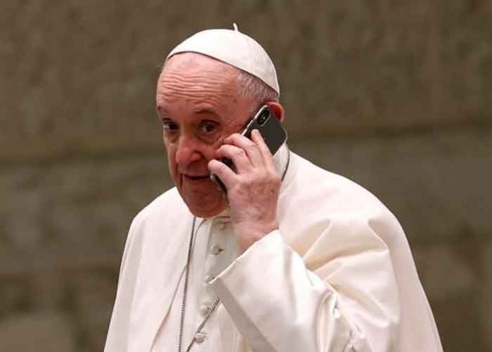 El papa Francisco habla por teléfono durante la audiencia general semanal en el Aula Pablo VI del Vaticano, el 11 de agosto de 2021. / FOTO / AP Photo / Riccardo De Luca