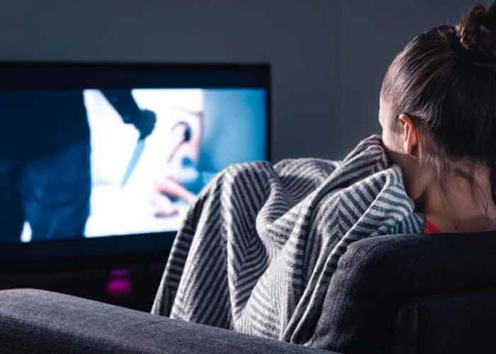 Una mujer sentada viendo una película de terror en su tv / Imagen referencial / Pixabay