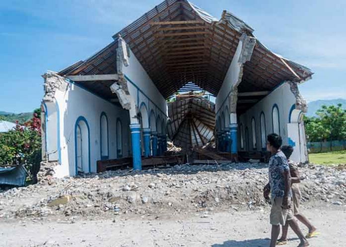 Un joven camina frente a una iglesia destruida por el potente sismo de 7,2 grados en Haití / FOTO / AFP