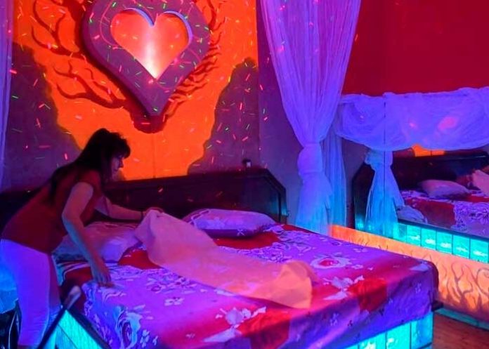 Mujer arreglando una cama para un set de cine porno en Francia