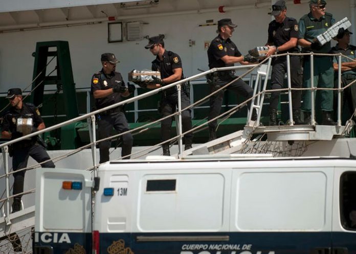 Policías nacionales y guardias civiles descargan paquetes de droga en España, 2013