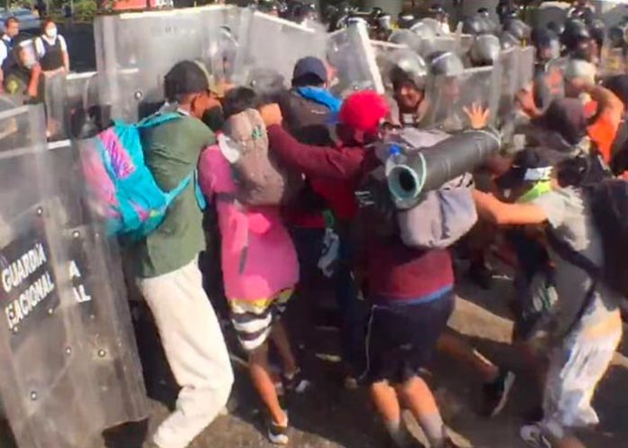 Migrantes rompen cerco durante enfrentamiento con la Guardia en México