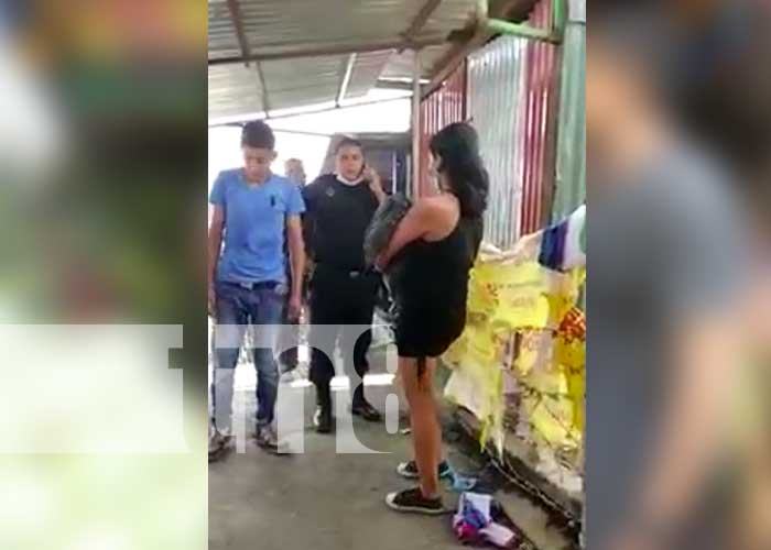 Mujer carga bebé muerto en una parada de buses en Managua