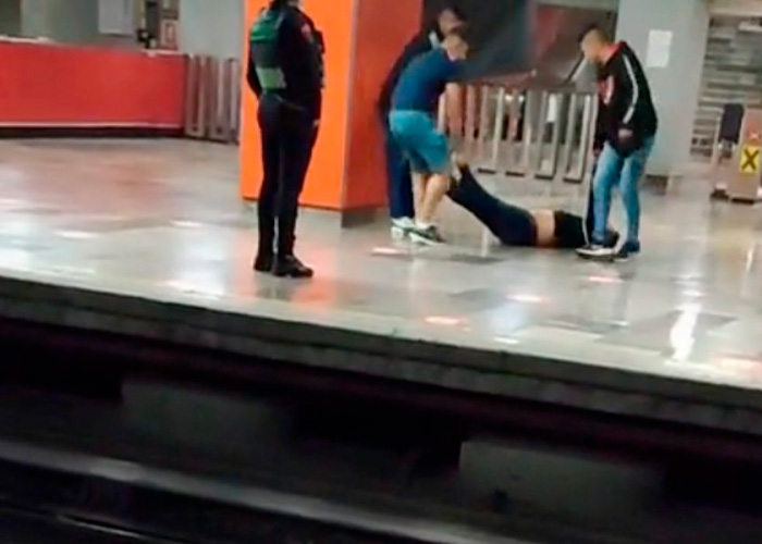 Cargan a su amigo borracho en el metro de México