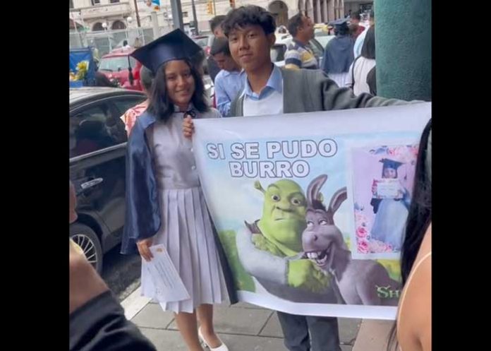 Joven asiste a la graduación de su hermana con cartel 