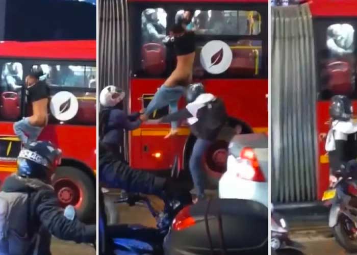 Desnudo y colgado de la ventana de un bus