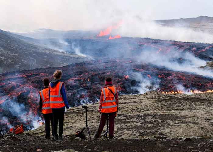Observadores de la Universidad de Islandia observan una erupción volcánica cerca de Litli Hrutur, Islandia, el 10 de julio de 2023.